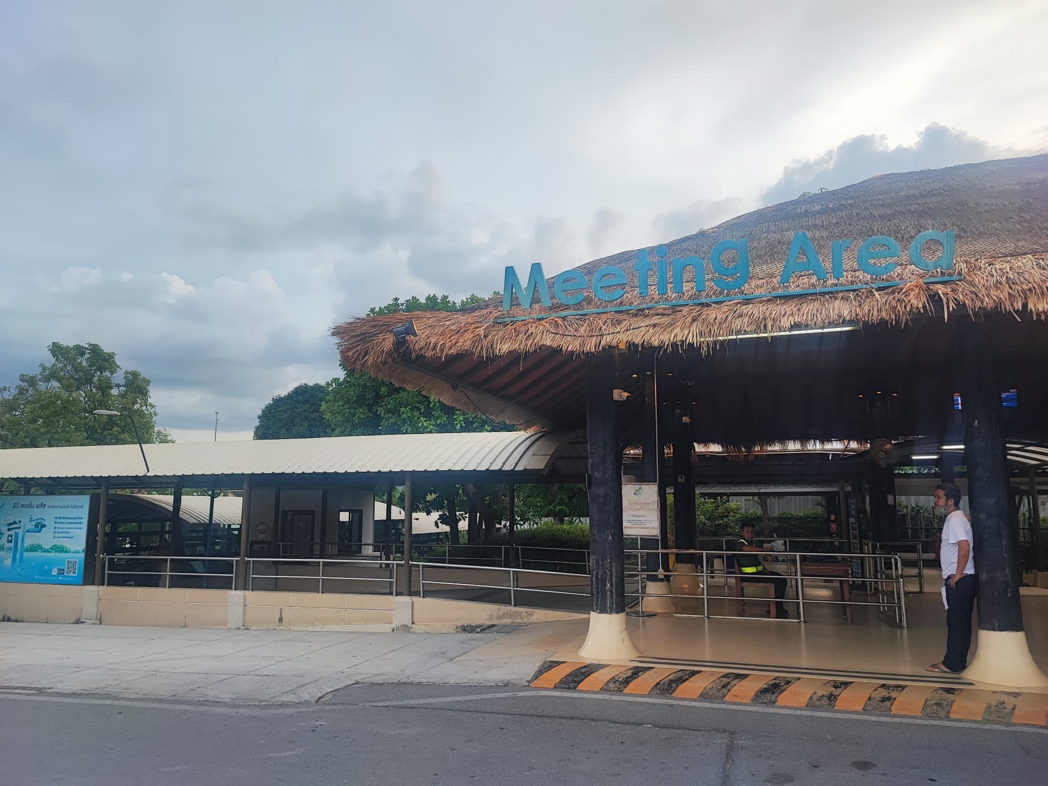 Large blue Meeting Area sign on a thatched-roof building at Samui Airport